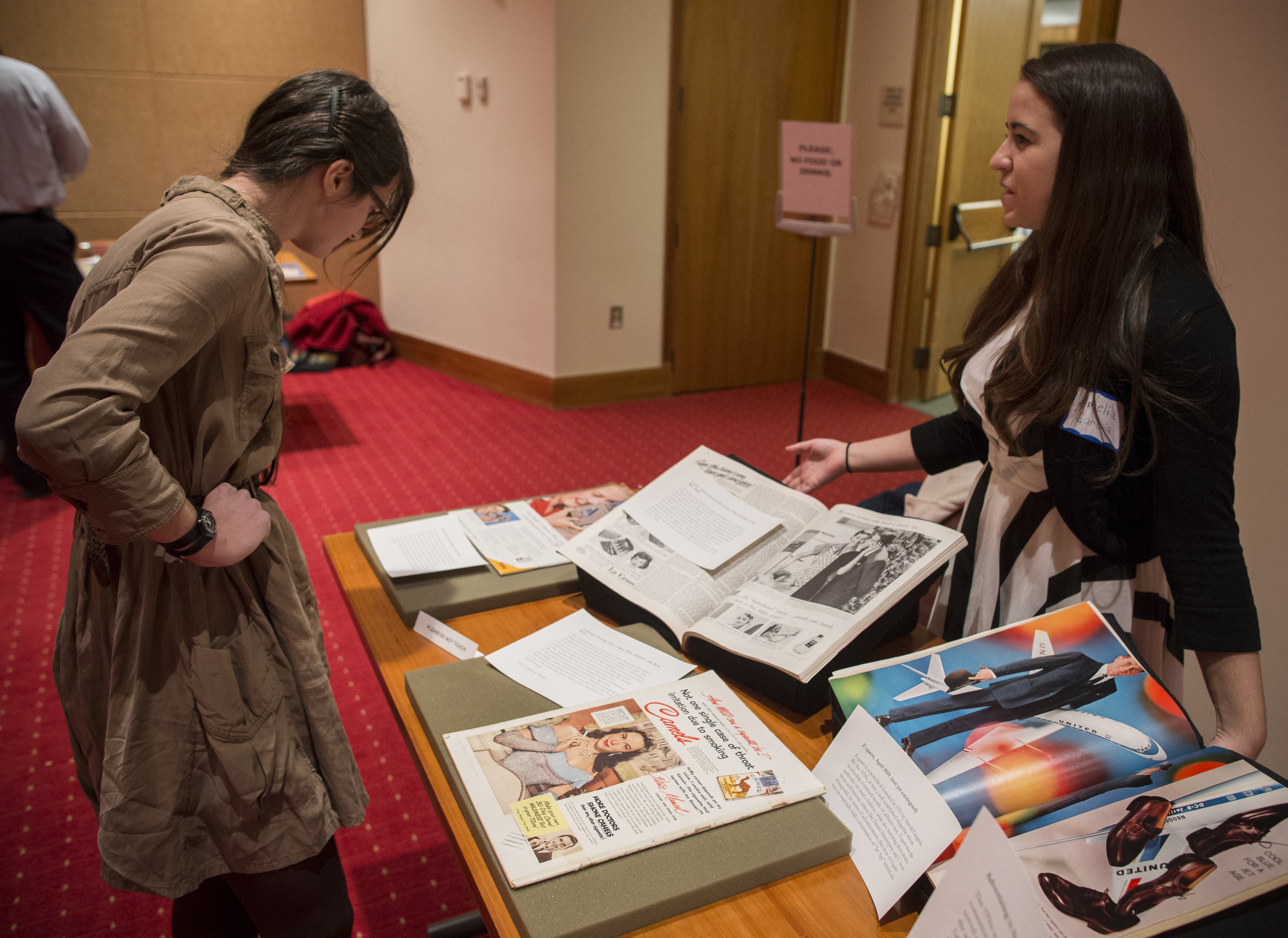 Amelia Garcia (right) talks to English graduate student and Special Collections employee about an advertisement from the 1950s, 19 November 2013. (Photograph by Sanjay Suchak)