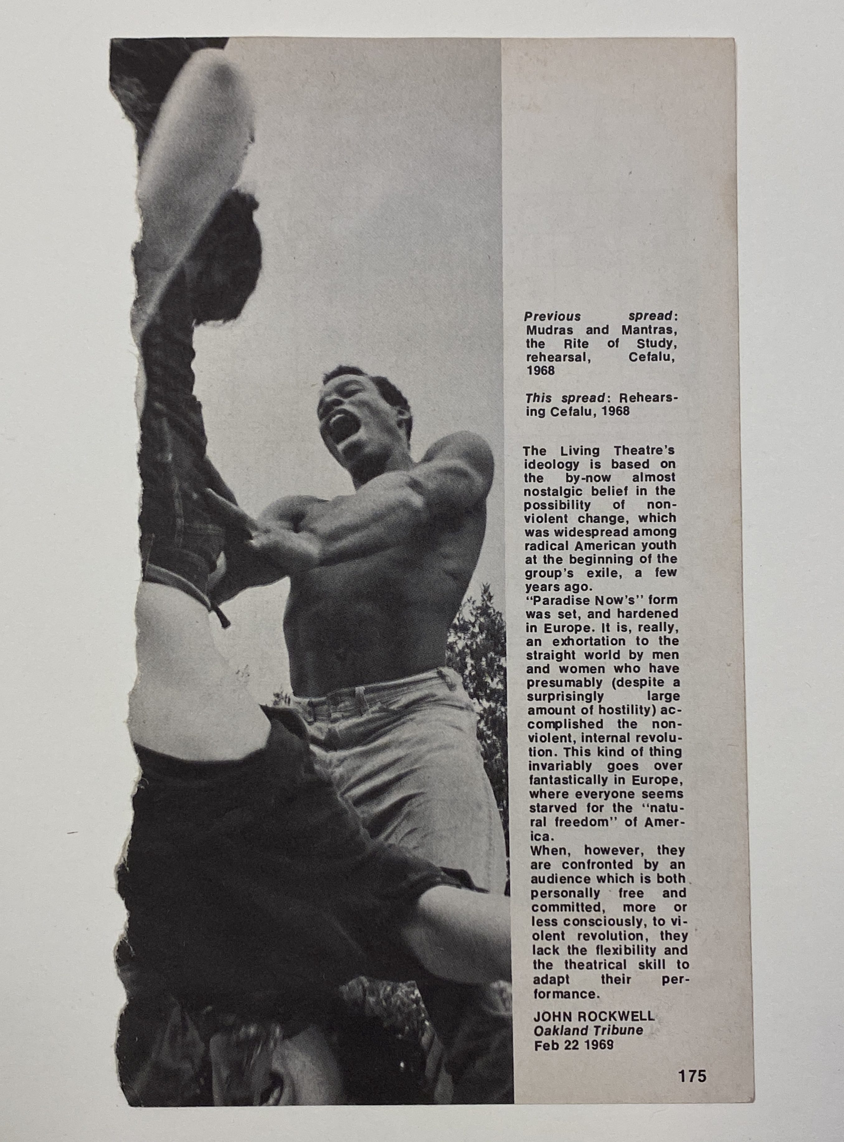 A page of a magazine, with the left margin torn, and a black and white photograph of a Black man with his mouth open wide, holding a white woman who is upside down with her mouth wide open, accompanied by a column of text on the right. 