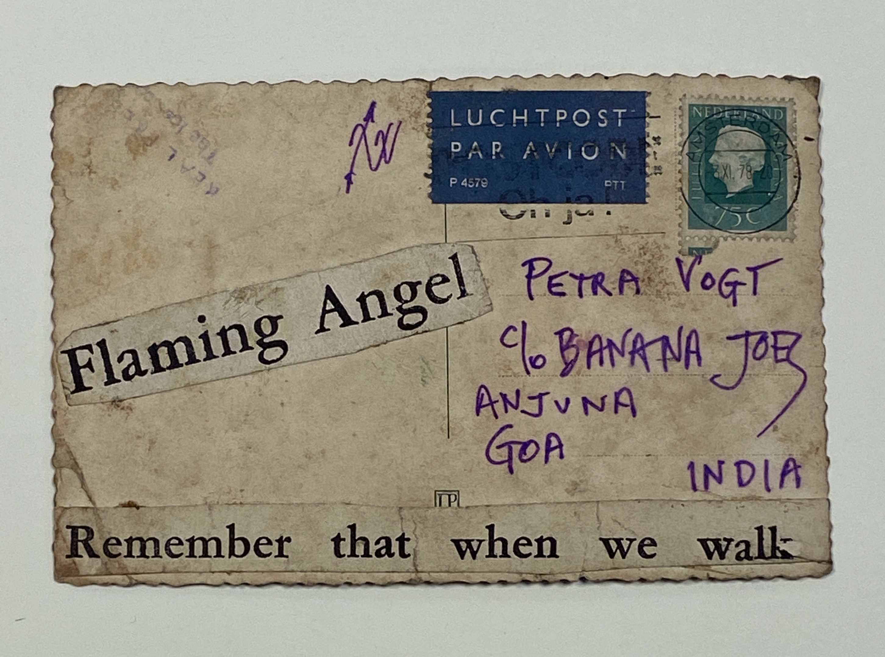 The text side of a commercial postcard with rippled edges, heavily soiled. Printed text is collaged onto the background, "Flaming angel / Remember that when we walk". The address is in violet ink and there are stamps. 