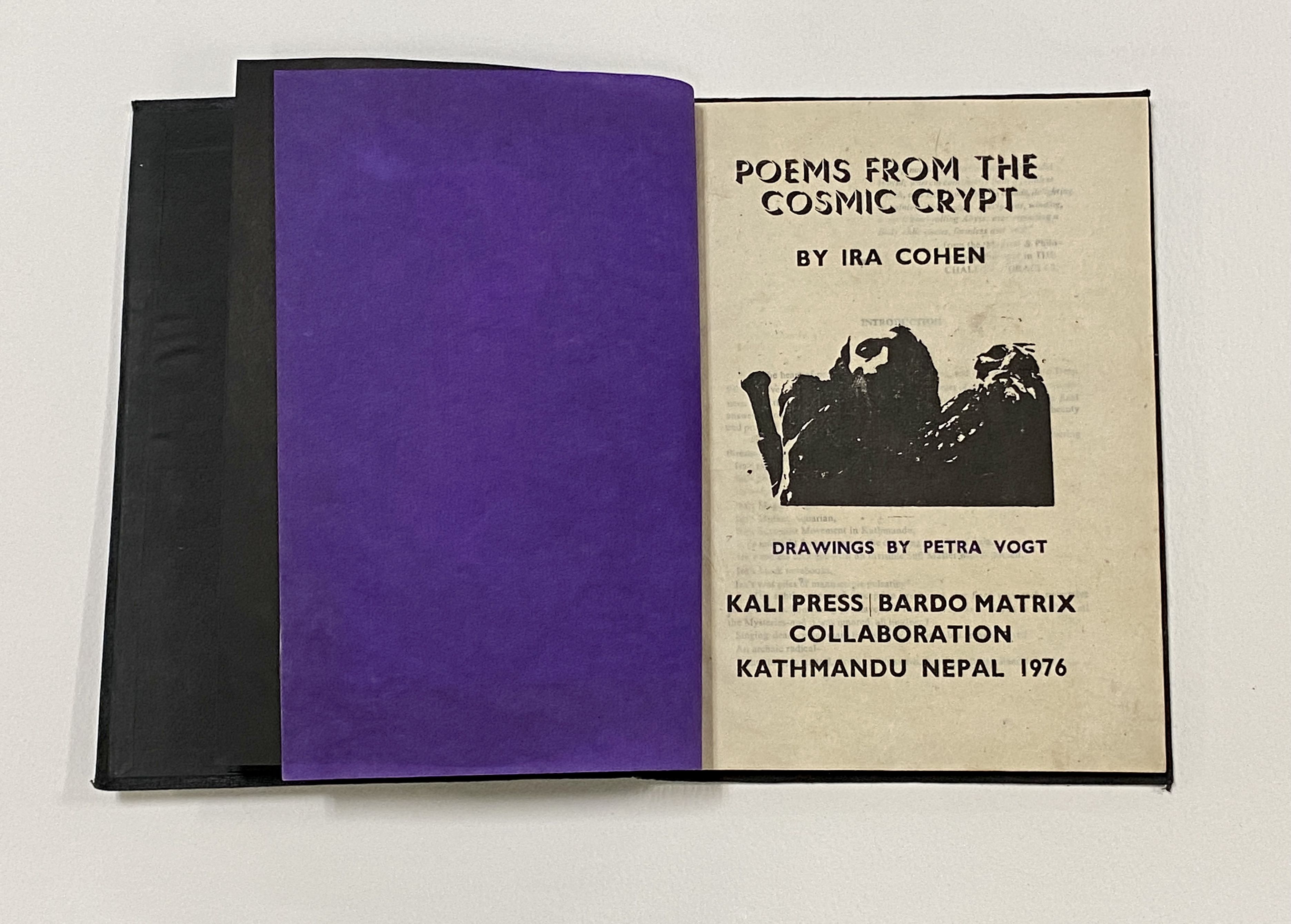 A hardcover book with black endpapers lies open on a surface, open to the title page. The verso is a deep purple, and the recto holds the title information and a black and white photographic image of a man. 